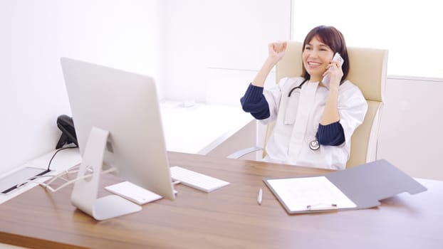 Female doctor calling a patient to communicate the good results of a medical test