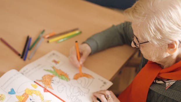 An old woman coloring a draw in a nursing home