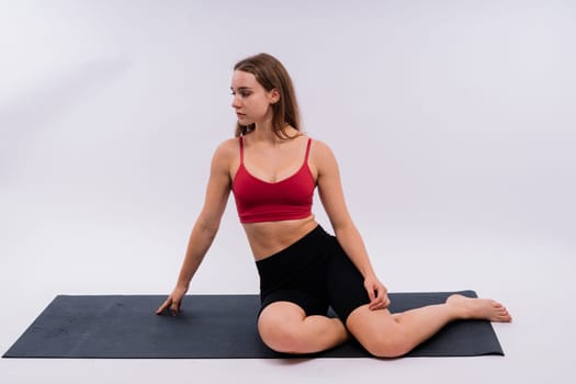 Beautiful female in yoga studio. A woman doing yoga. Lady in a top.