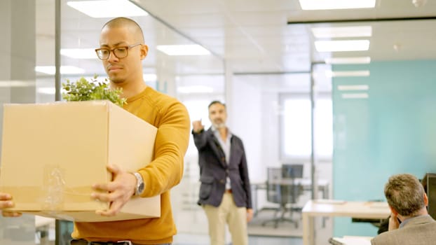 Boss directs the exit to a dismissed employee with a box containing their belongings