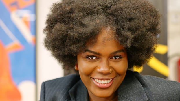 Close-up of african businesswoman smiling at camera in coworking