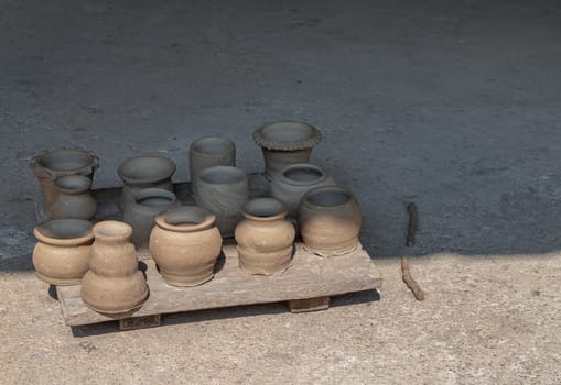 An empty of freshly made clay Pots. Clay pots background handmade art, Clay pots is drying under sun, Clay pottery, Space for text, Selective focus.