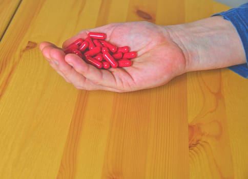 Many pills in a palm. Painful old age. Caring for the health of the elderly.