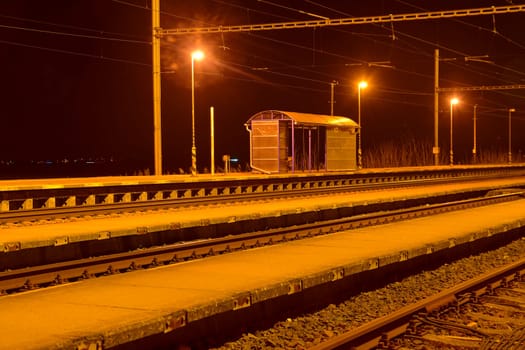 A small roofless train station at night in the Czech Republic.