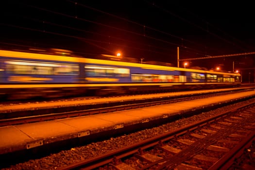 Passenger train on railroad tracks at night Blurred motion.