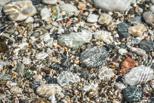 Top view of the stones in the water at the seaside and the sparkles of the water