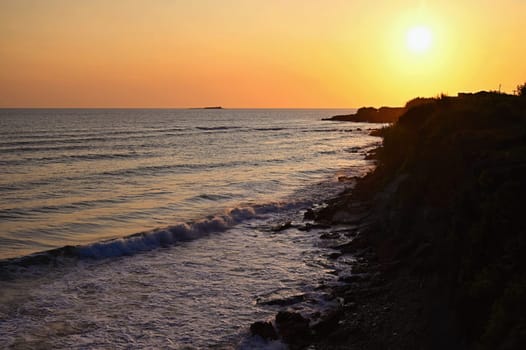 Beautiful sunset on the beach with the sea. Greece - island of Corfu (Kerkyra). Concept for travel, holidays and summer vacations. 