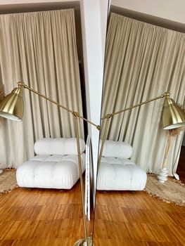 Reflection of a part of the interior with a lamp and an upholstered chair in the mirror. High quality photo