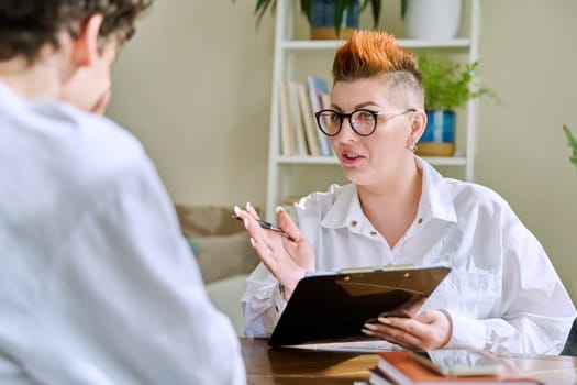 Female professional psychologist mental therapist working with young guy in office. Social worker counselor psychotherapist helping patient with difficulties stress depression. Psychology psychotherapy