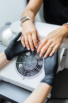 Young perfect woman's hands. Manicurist makes manicure to client. Nails care and manicure pedicure beauty salon