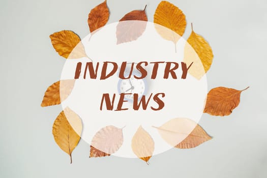 A circle of leaves with the words Industry News written in the center. The leaves are orange and brown and the circle is white