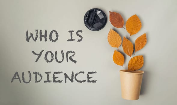 A plant with leaves and a cup with the words "who is your audience" written on it