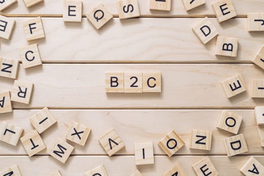 A bunch of wooden blocks with letters on them, including B2C. Concept of playfulness and creativity, as the blocks are arranged in a way that resembles a puzzle or a game