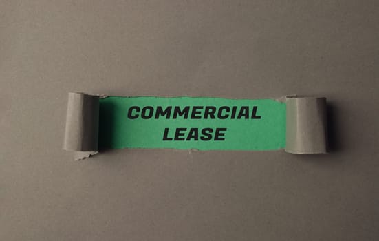 A torn piece of paper with the word commercial lease written on it. The paper is green and has a green border