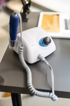 Electric manicure machine on table. Drill for manicure.