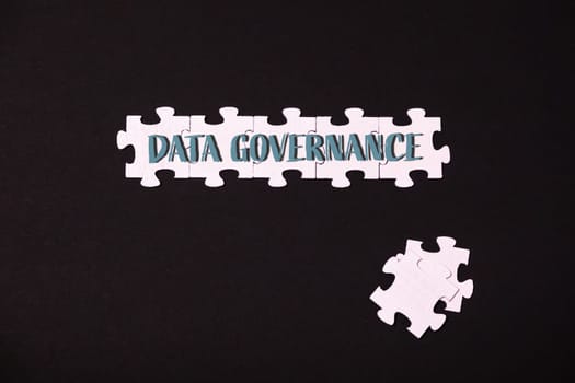 A jigsaw puzzle with the words Data Governance written on it. The puzzle is on a black background