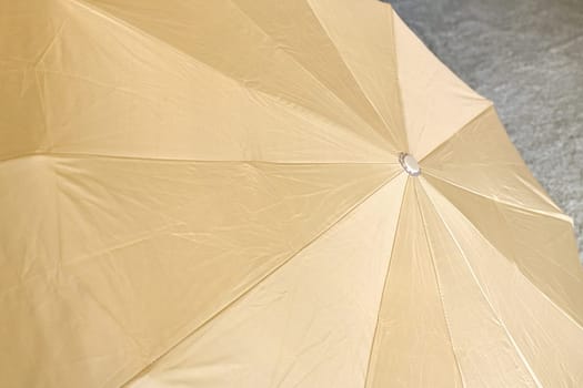 Background from open beige umbrella