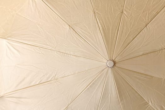 Background from open beige umbrella