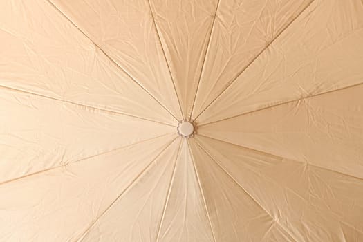 Background from open beige umbrella