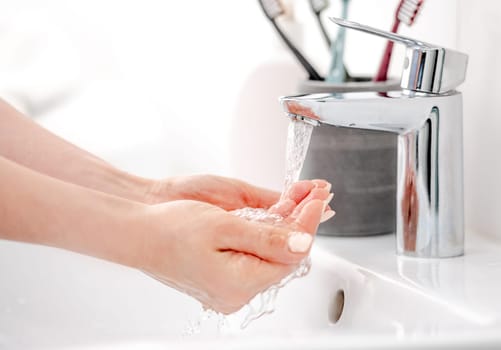 Female Hands Under A Faucet Fill Water Into Palms For Morning Hygiene
