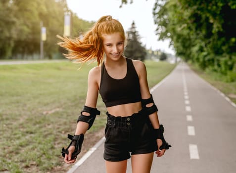 Teenage girl in sportswear enjoying roller skating in summer park