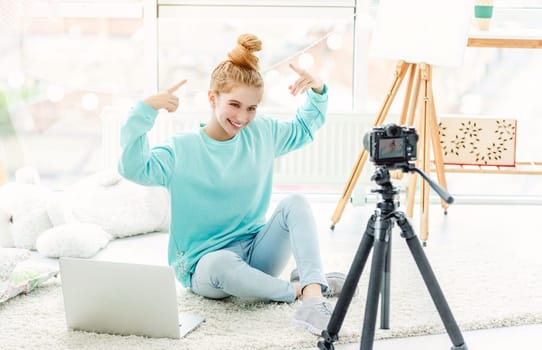 Beautiful girl hugging cute dog in front of camera on tripod