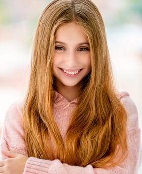 Cute long haired teenage girl smiling to camera