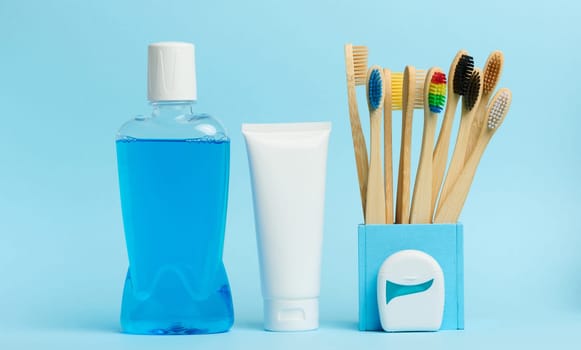 Mouthwash and toothpaste tube blue background, morning routine for oral hygiene