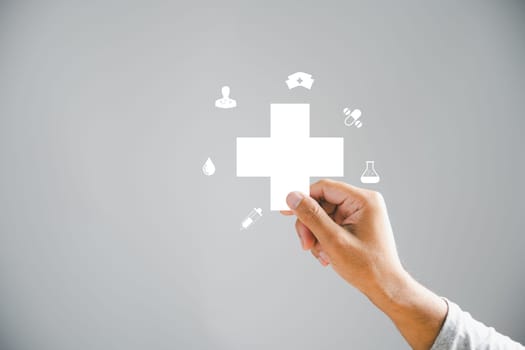 A plus icon is securely held by a male hand in isolation. A representation of positives, benefits, personal growth, health insurance, and growth. Emphasizing innovation in health care and technology.