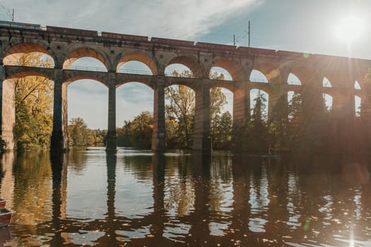 Railway Bridge with river in Bietigheim-Bissingen, Germany. Autumn. Railway viaduct over the Enz River, built in 1853 by Karl von Etzel on a sunny summer day. Bietigheim-Bissingen, Germany. Old viaduct in Bietigheim reflected in the river. Baden-Wurttemberg, Germany. Train passing a train bridge on a cloudy day in Germany