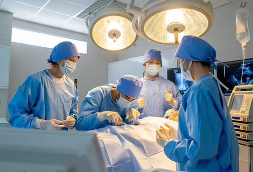 Operation team with blue clothes compose of nurse and doctor help to treatment patient in operation room with serveral tools and instruments of life support in hospital.