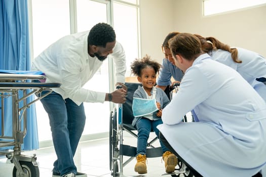 Doctor team help and take care child patient who injury with broken arm and sit on wheelchair and they look happy stay in emergency room.