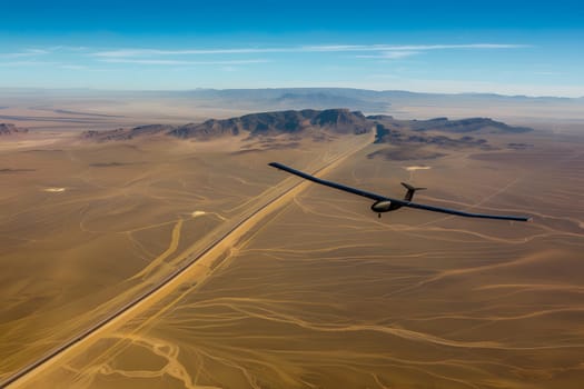 High-altitude image of an unmanned, solar-paneled army drone in flight above a vast desert terrain under blue sky, showcasing advanced technology and surveillance.