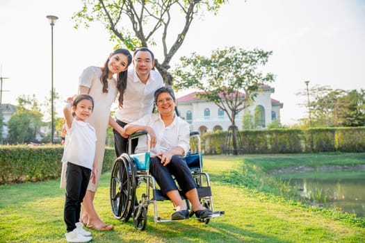 Asian family stay in garden in area of their home village with soft light in evening and they look at camera with smiling.