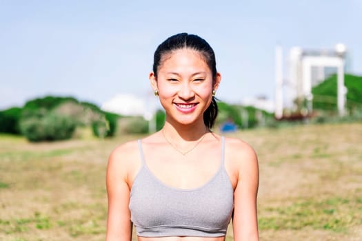 Portrait of a young asian woman in sportswear smiling happy looking at camera