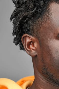 Close-Up View of African Mans Hair and Ear Against a Grey Background studio shot