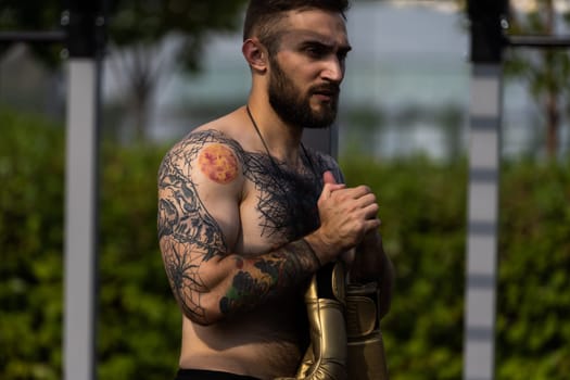 a man trains on the street with exercise machines.