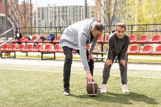 Family Playing American Football Together In Park