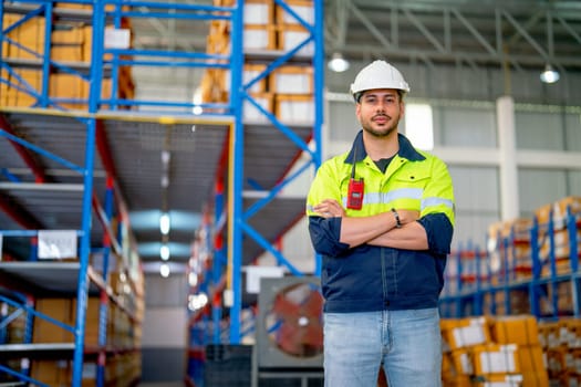 Portrait of Caucasian professional warehouse worker stand with arm-crossed and look at camera stand in front of shelves with cardbox of product in workplace.