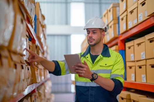 Professional warehouse worker hold tablet and check the product on shelves in workplace. The concept of good system support the worker for stock and shipment factory industry.