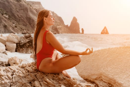 Woman sea yoga. Back view of free calm happy satisfied woman with long hair standing on top rock with yoga position against of sky by the sea. Healthy lifestyle outdoors in nature, fitness concept.