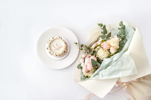 Festive bento cake and bouquet on a light background. High quality photo