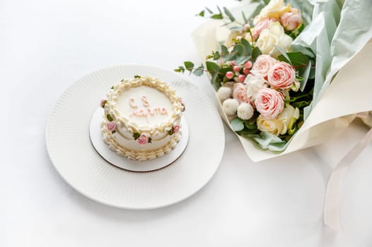 Festive bento cake and bouquet on a light background. High quality photo