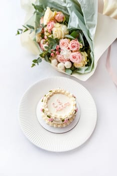 Festive bento cake and bouquet on a light background. High quality photo