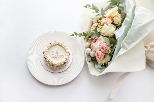 Festive bento cake and bouquet on a light background. High quality photo