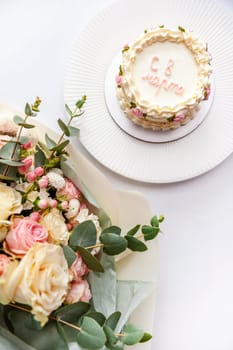 Festive bento cake and bouquet on a light background. High quality photo