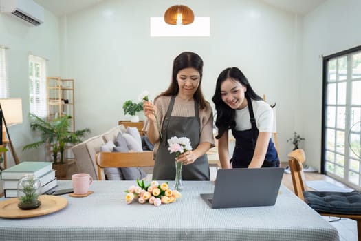 Mother and daughter arrange flower together at home on the weekend, family activities, mother and daughter do activities together on Mother's Day.