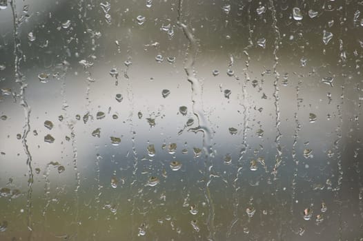 Window glass surface that has a textured pattern created by several water droplets of different sizes