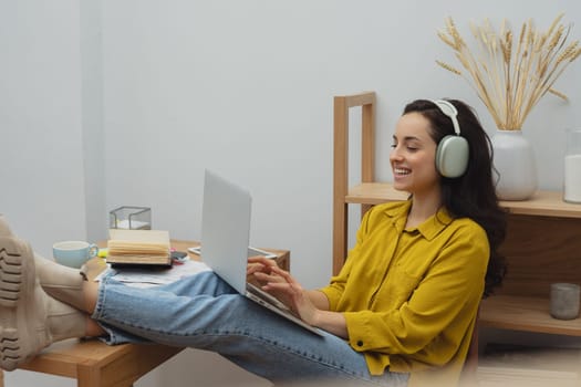 Thoughtful young woman in eyewear using computer while sitting on the sofa at home. High quality photo