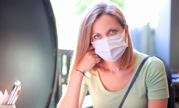 Portrait of young beautiful woman in protective mask on street. Disease prevention concept